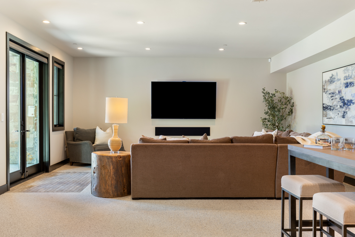 Lower-level family room with wet bar seating and patio access