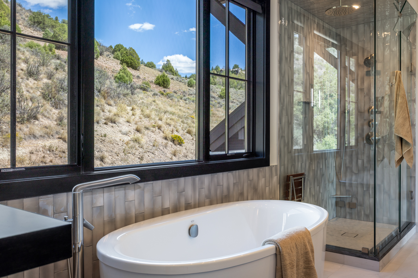 Primary bath with freestanding soaking tub and hillside views