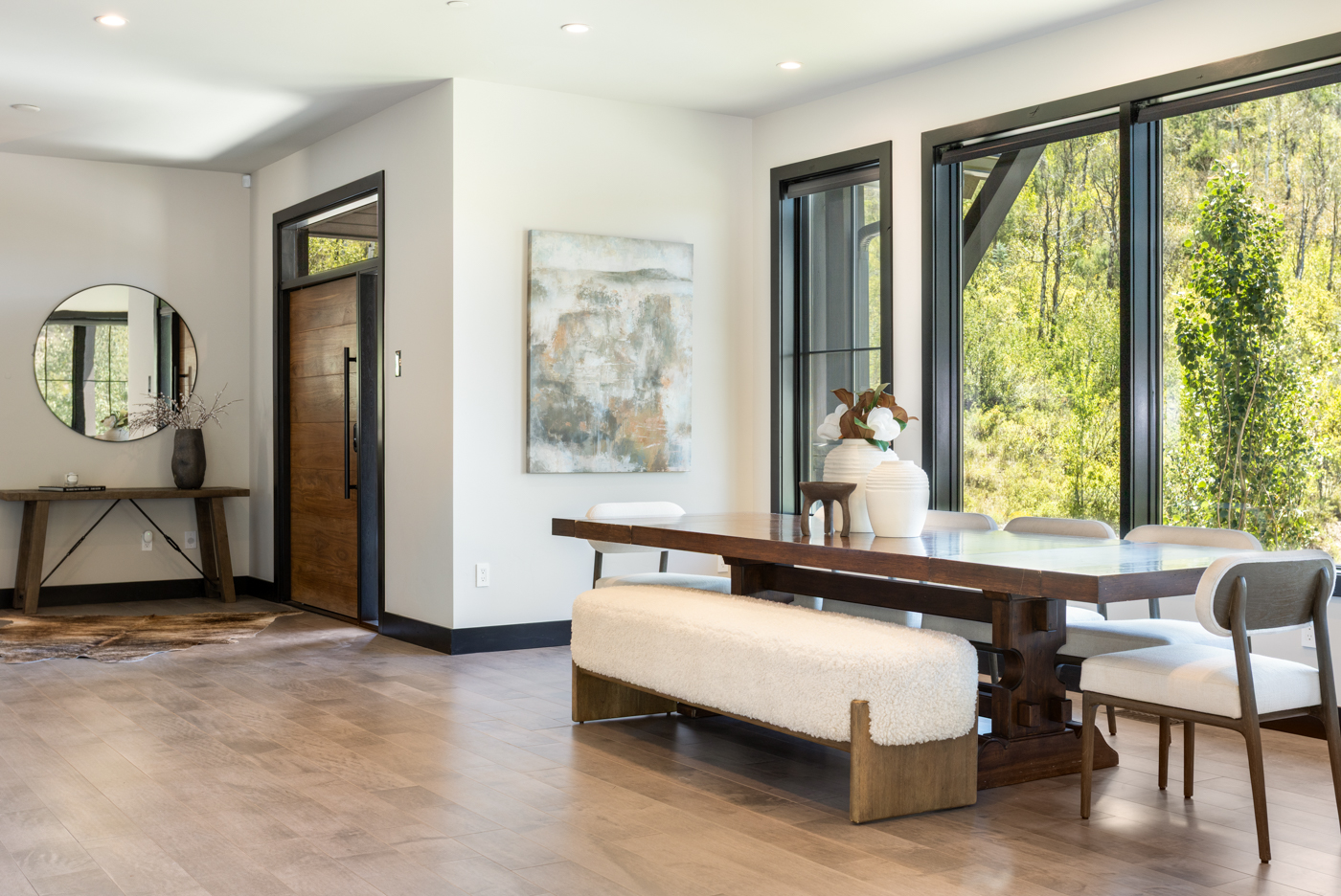 Entry foyer and dining table beside walls of glass