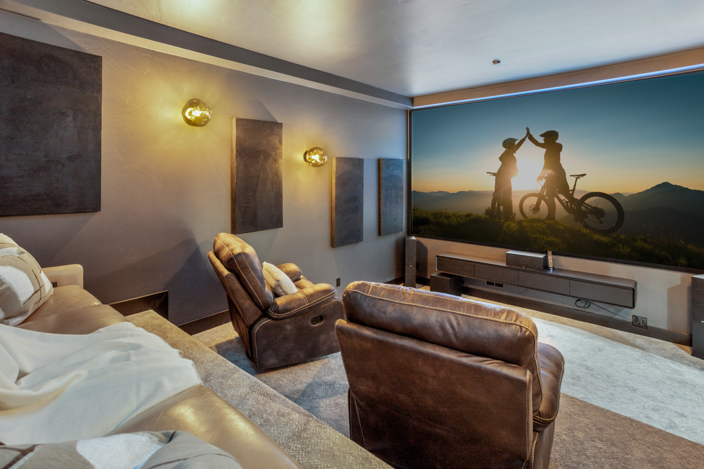 Theater screen wall with sconce lighting and reclining seats