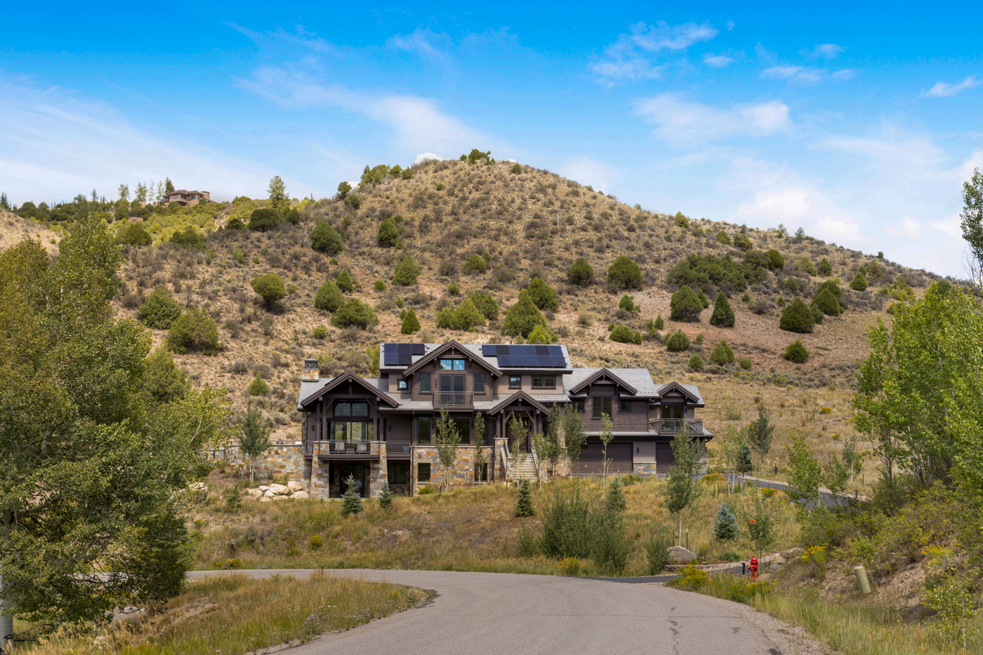 Aspen-framed approach with the home set against the ridgeline