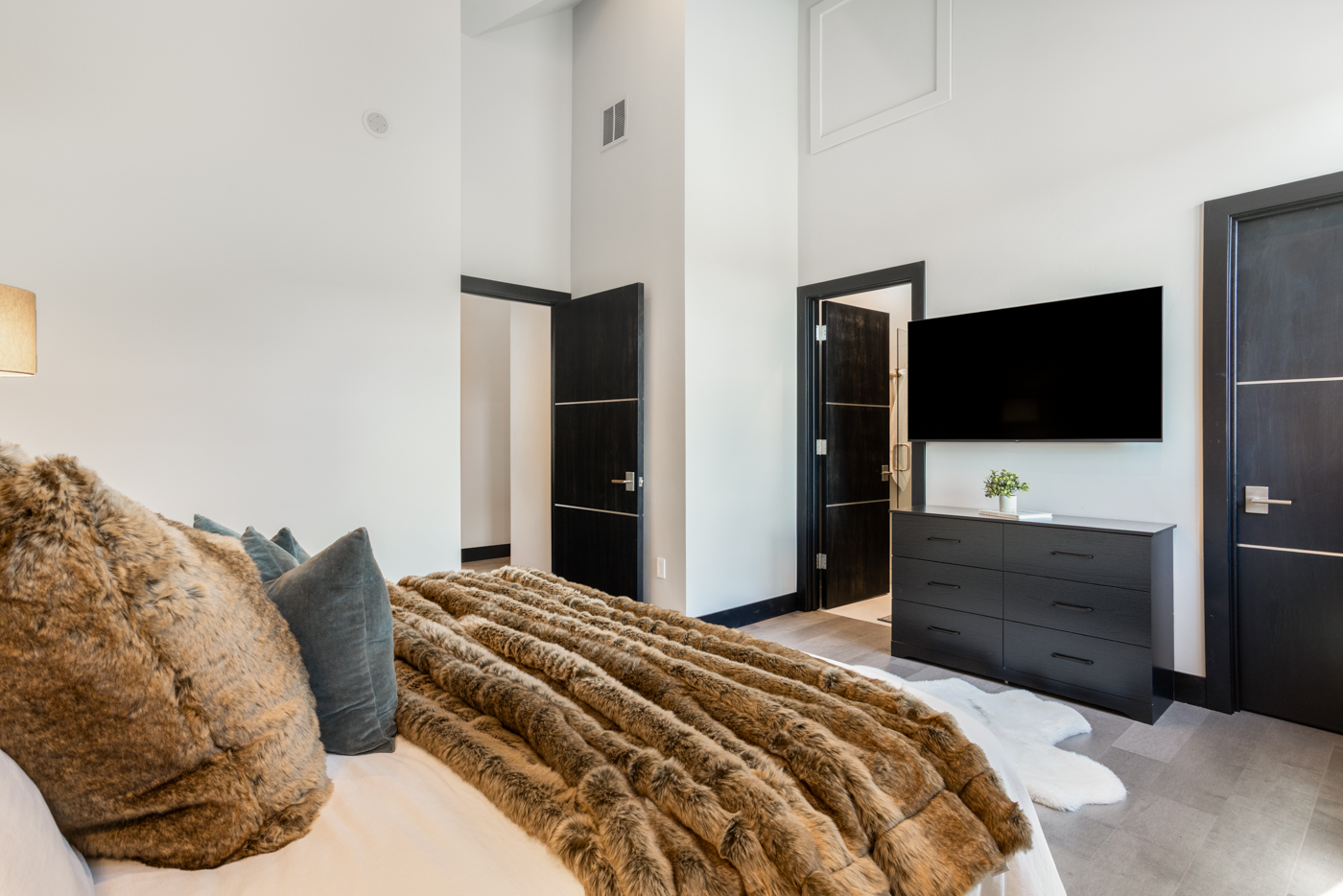 Guest bedroom with soaring ceilings and ensuite access