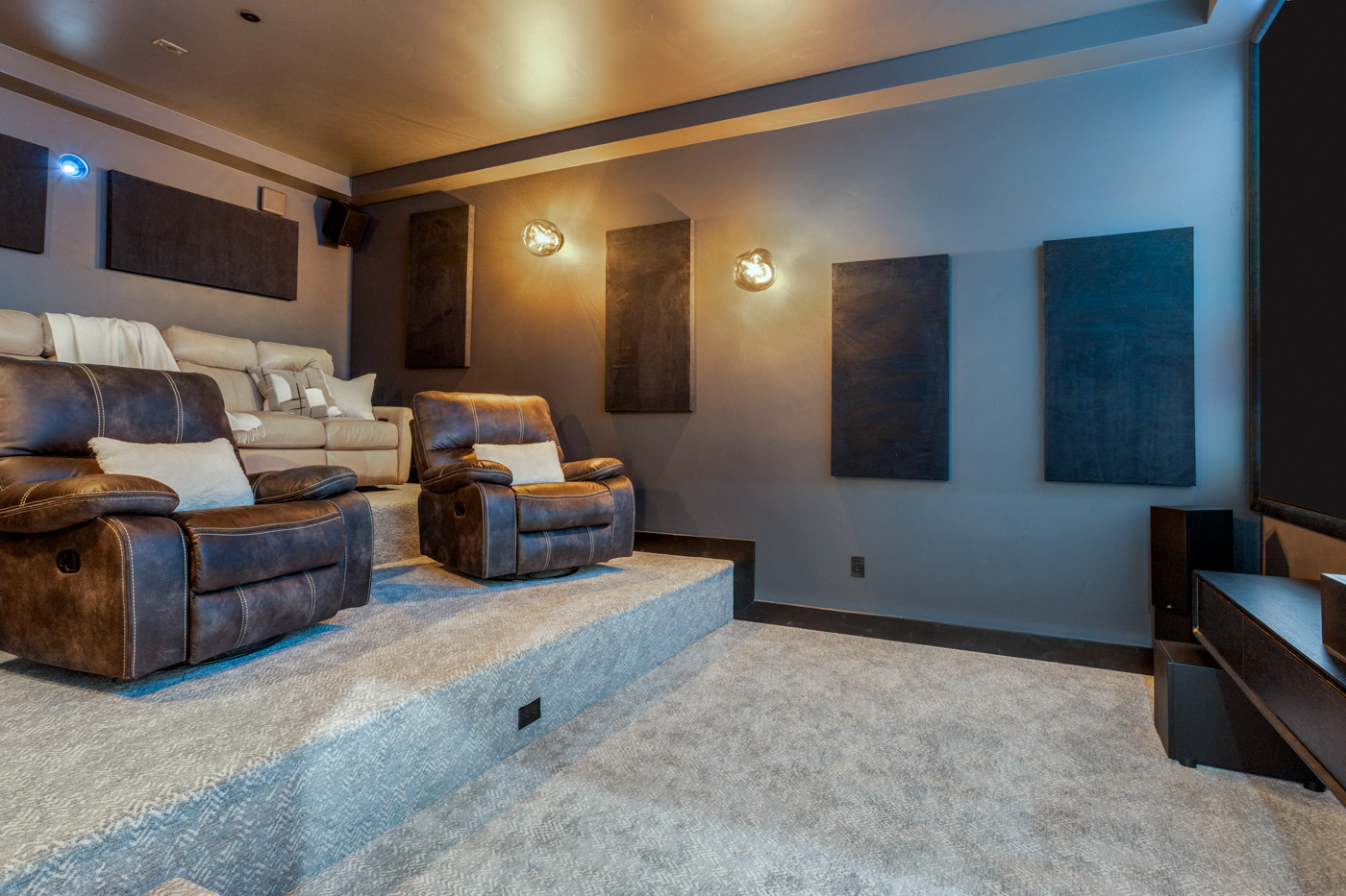 Home theater with tiered seating and acoustic wall panels