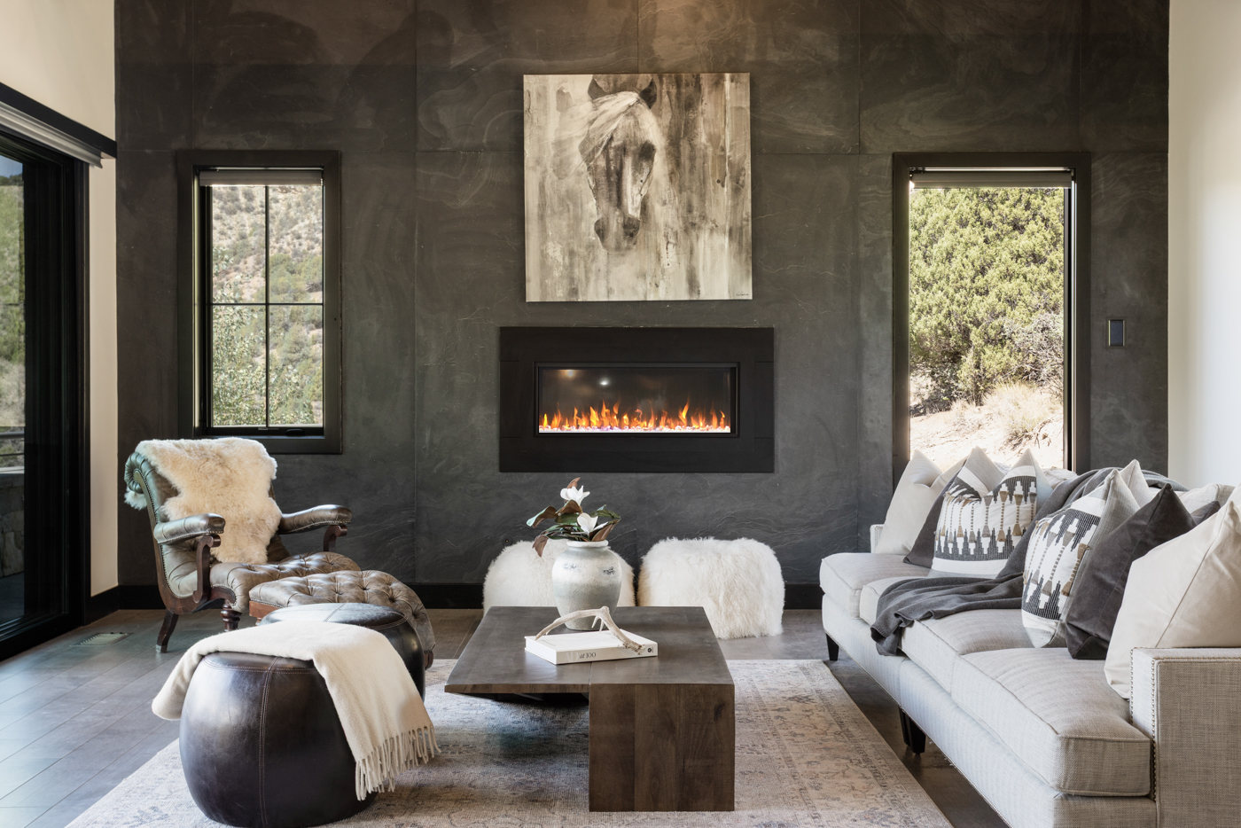 Fireplace wall with mountain views through steel-framed windows