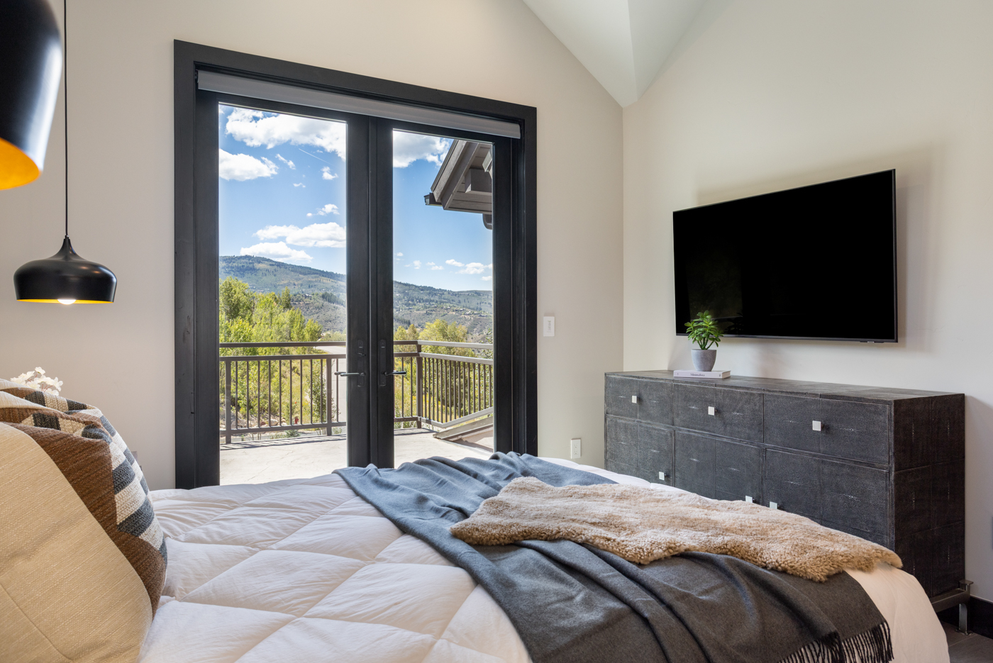 Guest bedroom deck doors framing mountain views